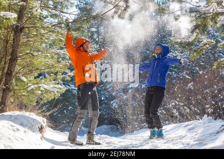 Jeune garçon et fille en vêtements d'hiver appréciant la neige dans le forêt Banque D'Images