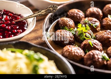 Boulettes de viande Kottbullar de cuisine suédoise, servies dans une casserole avec une purée de pommes de terre, du persil et de la sauce aux canneberges. Banque D'Images