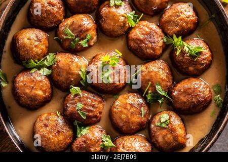 Vue de dessus d'une casserole avec des boulettes de viande de kottbullar fraîchement préparées dans une sauce. Banque D'Images