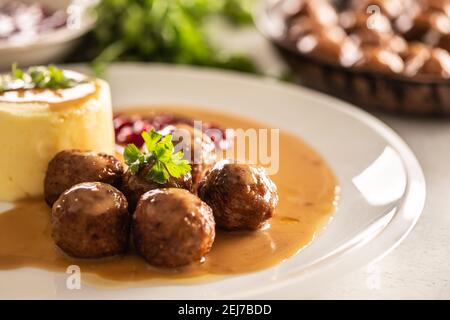 Assiette servant des boulettes de viande suédoises kottbullar en sauce avec purée de pommes de terre et sauce aux canneberges. Banque D'Images