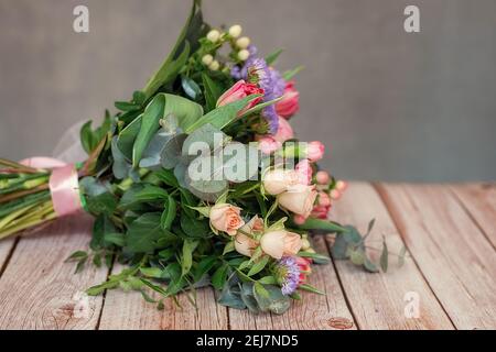 Vue rapprochée d'un beau bouquet de fleurs de coloful mélangées sur une table en bois. Le concept d'un fleuriste et de la livraison de fleurs comme une entreprise familiale, Banque D'Images