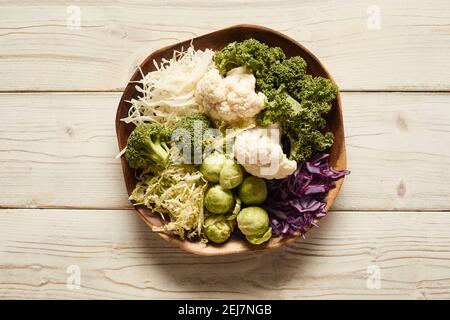 Vue de dessus du brocoli naturel et du chou-fleur avec choux de Bruxelles et kale placé au milieu du chou haché dans un bol sur bois tableau Banque D'Images