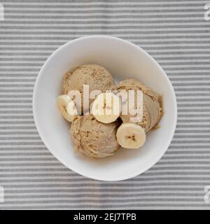 Crème glacée Banana au beurre de cacahuète maison dans un bol, vue du dessus. Pose à plat, en hauteur, par le dessus. Banque D'Images