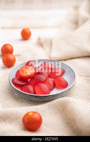 Bonbons de tomates en gelée sur fond de bois blanc et toile de lin. Gros plan, vue latérale, mise au point sélective. Banque D'Images