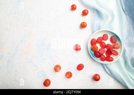 Bonbons à la tomate en gelée sur fond de béton blanc et linge bleu. Espace pour copier, vue de dessus, plat. Banque D'Images