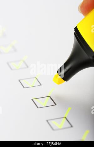 Marqueur jaune avec marqueurs sur la feuille de liste de contrôle. Concept de la tâche terminée de la liste de contrôle. Banque D'Images