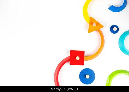 Formes géométriques en bois figurines de jeu colorées composition sur fond blanc. Vue de dessus Banque D'Images