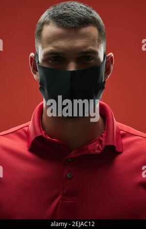 Gros plan portrait d'un homme beau en médecine masque regardant à l'appareil photo dans la pièce à l'intérieur Banque D'Images