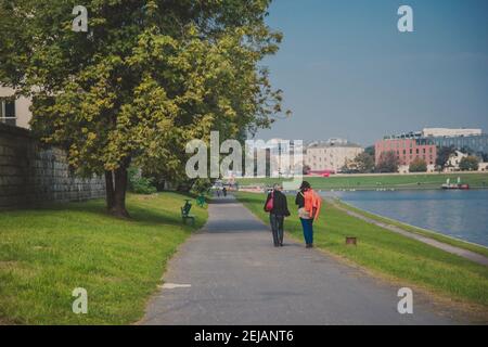 Les gens marchent le long de la promenade de la rivière Wisla Cracovie par une journée ensoleillée Banque D'Images