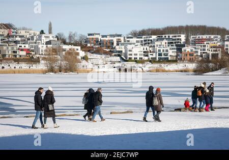 Dortmund, région de la Ruhr, Rhénanie-du-Nord-Westphalie, Allemagne - randonneurs au lac de Phoenix en hiver avec glace et neige, appartements de luxe et maisons à l'arrière Banque D'Images