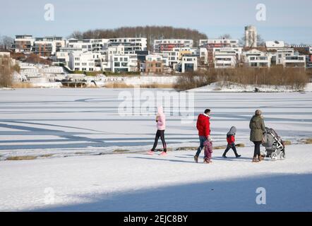 Dortmund, région de la Ruhr, Rhénanie-du-Nord-Westphalie, Allemagne - randonneurs au lac de Phoenix en hiver avec glace et neige, appartements de luxe et maisons à l'arrière Banque D'Images
