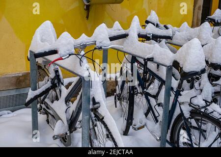 Certaines bicyclettes garées en hiver, couvertes de neige. Banque D'Images