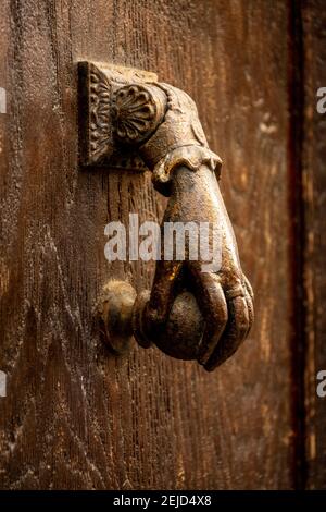 Frappeur de porte vintage en forme de main sur une entrée en bois Banque D'Images