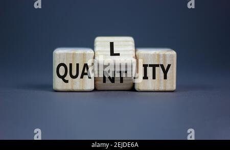 Symbole de qualité supérieure à la quantité. Les cubes ont été tournés et le mot « quantité » a été remplacé par « qualité ». Belle table grise, fond gris, espace de copie. Affaires a Banque D'Images