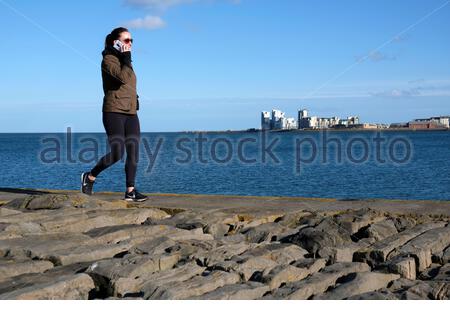 Édimbourg, Écosse, Royaume-Uni. 22 février 2021. Les gens qui apprécient le port de Granton et le petit-déjeuner dans un après-midi froid et ensoleillé. Vue sur le développement moderne à Leith. Crédit : Craig Brown/Alay Live News Banque D'Images