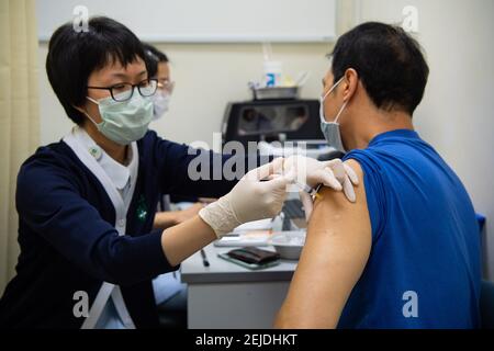 Macao, Chine. 22 février 2021. Un homme reçoit une injection du vaccin COVID-19 dans une station de vaccination COVID-19 à Macao, Chine du Sud, le 22 février 2021. La région administrative spéciale de Macao (RAS) a commencé lundi à inoculer aux résidents locaux qui ne font pas partie des groupes prioritaires les vaccins COVID-19 produits par le continent. Lundi, environ 15,000 résidents de Macao avaient fait des réserves pour l'inoculation et plus de 3,000 dans les groupes prioritaires avaient terminé l'inoculation, selon le centre. Crédit: Cheong Kam Ka/Xinhua/Alay Live News Banque D'Images