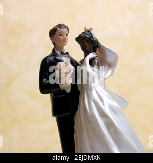 Gâteau de mariage topper avec un marié dans un smoking noir et une mariée dans une robe blanche avec un bouquet Banque D'Images