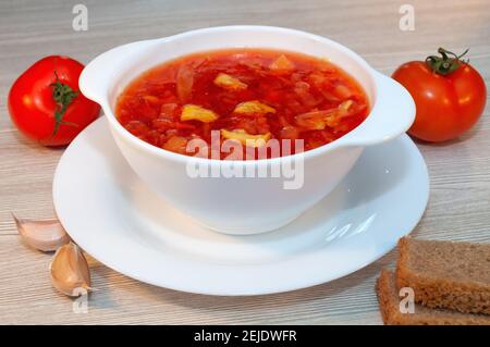 Soupe de borscht avec viande dans un bol blanc sur une table en bois. Banque D'Images