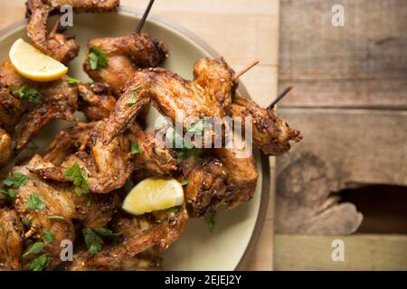 Les ailes de poulet britanniques qui ont été marinées dans des épices au Chili et un assaisonnement à l'hatar avant d'être brochées sur des brochettes de bambou, puis grillées. FR Banque D'Images