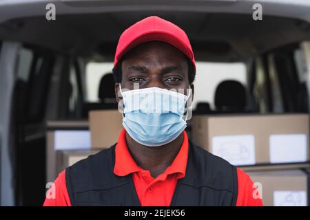 Homme de livraison africain travaillant tout en portant un masque facial à éviter virus corona propagation - les personnes travaillant avec la livraison rapide pendant épidémie de virus corona Banque D'Images