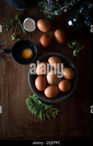 Œufs frais non cuits dans un bol rustique sur fond de bois naturel. Œufs de poulet crus sur fond de bois. Banque D'Images