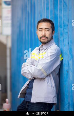 Portrait d'un travailleur ou d'un technicien souriez et tenez le contenant Banque D'Images