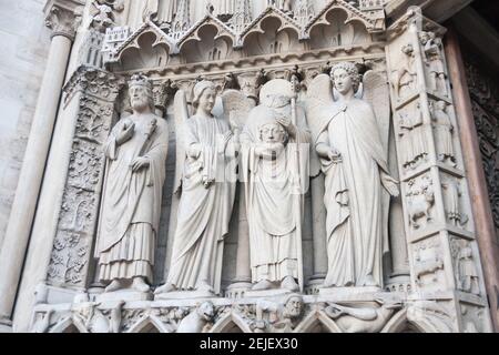 Statue de Saint-Denis tenant sa tête avec d'autres saints sur la façade extérieure de la cathédrale notre-Dame de Paris à Paris, France Banque D'Images