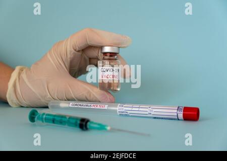 Injection de coronavirus COVID-19 dans les mains du médecin, petit flacon d'ampoule avec test PCR Banque D'Images