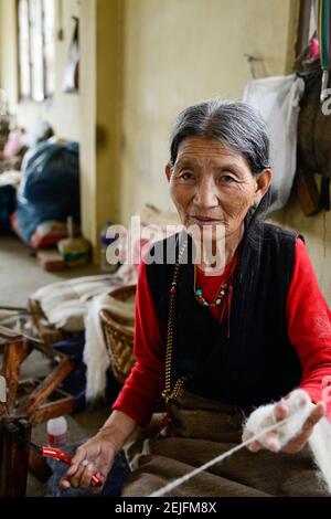 NÉPAL Katmandou, Lalitpur, tibetische Fluechtlinge, tibetisches Fluechtlingslager Jawalakhel, Teppichfabrik JHC Jawalakhel Handrift Centre, tibetische Frauen spinnen die Wolle, Frau Kunsang, 72 Jahre Banque D'Images