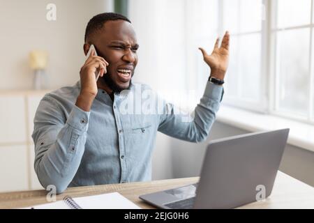 Un homme d'affaires en colère qui parle au téléphone criait qu'il y avait un problème sur le lieu de travail Banque D'Images