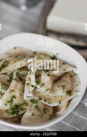 Boulettes, remplies de pommes de terre et servies avec du beurre et du fenouil. Varenyky, vareniki, pierogi, pyrohie. Boulettes avec remplissage Banque D'Images