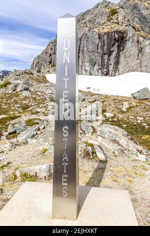 Un poste métallique marquant la frontière entre le Canada et les États-Unis à côté de la route Klondike ne de Skagway, Alaska, États-Unis Banque D'Images