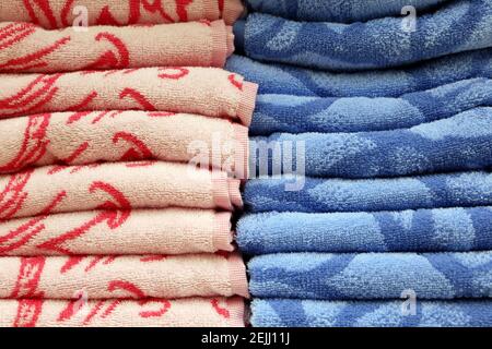 Pile de serviettes en éponge colorées. Fond doux, tissu de bain rose et bleu gros plan Banque D'Images