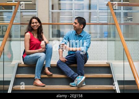 Deux collègues de travail discutent, écoutent et se rattrapent dans l'espace commun d'un bureau Banque D'Images