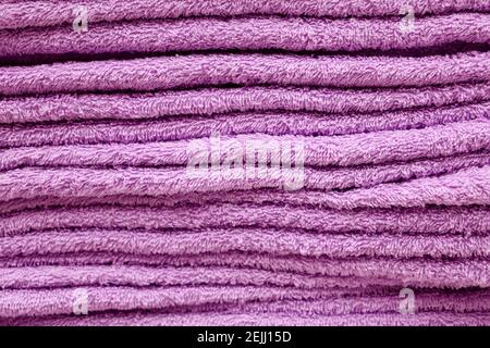 Pile de serviettes en tissu éponge, mise au point sélective. Fond doux, tissu de bain violet gros plan Banque D'Images