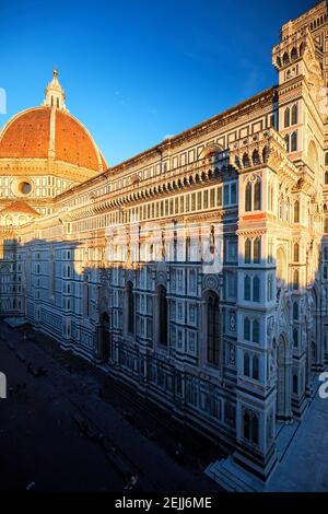 Vue aérienne et verticale de la cathédrale Sainte-Marie de la Fleur à Florence. Dôme et rue gothiques, illuminés par la lumière rouge du soleil couchant. UNESCO Banque D'Images