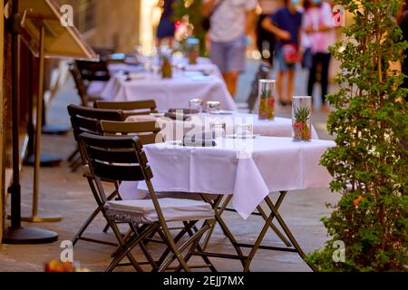 Vacances d'été en Toscane. Des tables décorées sur une nappe blanche dans la rue attendent les clients. Pienza, Italie Banque D'Images