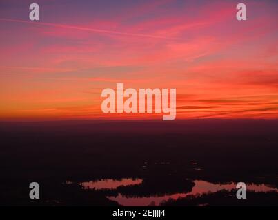 Ciel rouge-orange après le coucher du soleil. Les nuages rouges se reflètent dans les lacs. Photographie aérienne, moody shot. Photos parfaites pour l'échange en arrière-plan. Banque D'Images