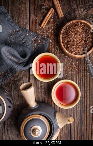 Thé Rooibos fraîchement préparé rempli d'antioxydants sur fond de bois Banque D'Images