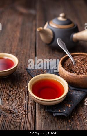 Thé Rooibos fraîchement préparé rempli d'antioxydants sur fond de bois Banque D'Images