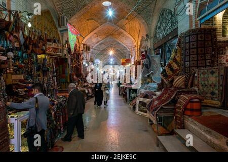 Shiraz, Iran - 04.12.2019: Personnes marchant dans une allée du bazar Vakil à Shiraz, Iran. Beaucoup de tapis et de lumières colorés. Oriental traditionnel Banque D'Images