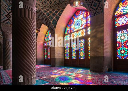 Shiraz, Iran - 04.07.2019: Intérieur de la Mosquée Rose à Shiraz. Ornements islamiques, le soleil brille à travers le verre coloré et projette de la couleur à l'intérieur. Banque D'Images