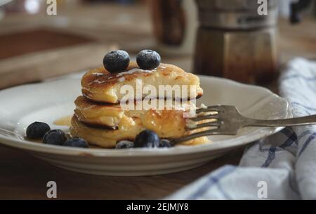 Délicieux cheesecakes maison, coupés avec une fourchette arrosée de bleuets frais, Banque D'Images