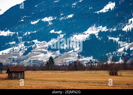 Structure d'entrepôt en bois pour stocker le foin et le bois de chauffage pour les peuplements d'hiver en premier plan dans le champ, grande montagne est visible dans le backgro Banque D'Images