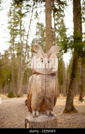 ChainSAW Wood Art Orhibou animal sculpté dans une forêt de bois de pin avec de nombreux arbres en rondins pour la sculpture et l'artisanat fait à la main en bois. Banque D'Images