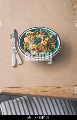 Salade de satay au poulet sur une table rustique et du papier artisanal Banque D'Images