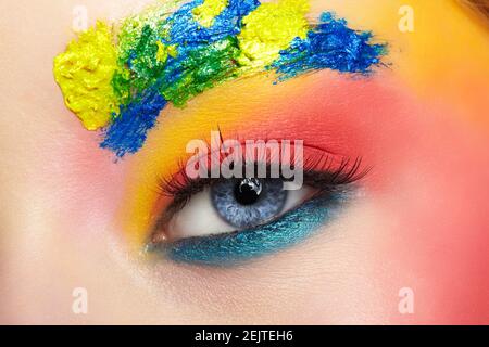 Gros plan de l'œil d'une jeune fille avec maquillage artistique inhabituel. Peinture féminine sur le visage sur les sourcils et autour des yeux. Banque D'Images