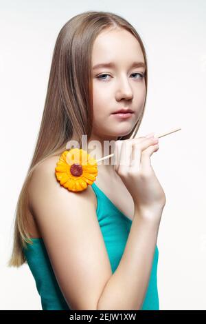 Adolescente avec une fleur en mains. Concept de dent douce. Banque D'Images