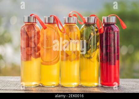 Cambucha avec divers fruits disposés sous forme d'arc-en-ciel. Thé kombucha cru fermenté fait maison avec différents arômes. Naturel sain Banque D'Images