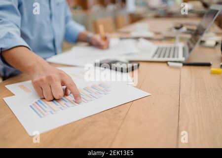 Homme d'affaires remet un graphique papier de point et vérifie le calculateur de données de document pour calculer la comptabilité budgétaire. concept de finance et de comptabilité Banque D'Images